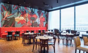 a restaurant with tables and chairs and a mural at Thon Hotel Kirkenes in Kirkenes