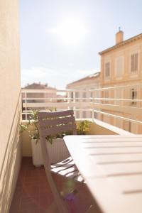 un banc en bois assis sur le balcon d'un bâtiment dans l'établissement Esperanto, à Cannes