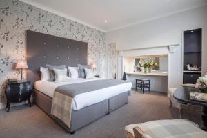 a bedroom with a large bed and a living room at The Roseate Villa Bath in Bath