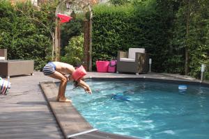 a woman is bending over in a swimming pool at Côté Jardin - Chambres d'hôtes in Senlis