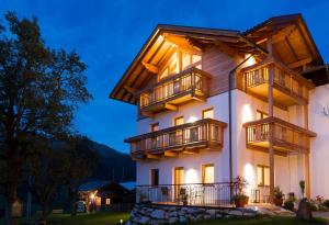 a large building with balconies on it at night at Alpenhof Wolayersee in Birnbaum