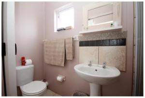 Un baño con un inodoro blanco y un lavabo. en Nahoon Bed & Breakfast, en East London 44 fotos más
