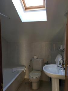 La salle de bains est pourvue de toilettes, d'un lavabo et d'une lucarne. dans l'établissement Apartamento Con Vistas Al Mar, à Villadesuso