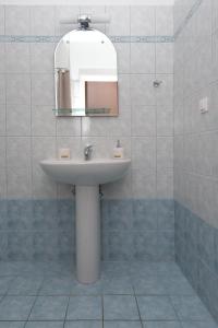 a bathroom with a sink and a mirror at Cosy 3bedroom Apartment in Sami