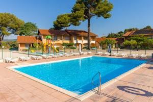 a swimming pool with lounge chairs and a resort at Azureva La Londe les Maures in La Londe-les-Maures