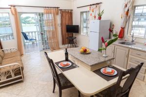 una cucina e una sala da pranzo con tavolo e sedie di Bayside Villa St. Lucia a Castries