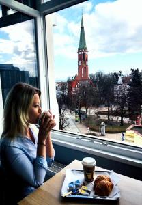 Eine Frau, die an einem Tisch mit einem Teller Essen sitzt. in der Unterkunft Central Sopot in Sopot