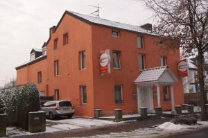 ein rotes Backsteingebäude mit einem davor geparkt in der Unterkunft Hotel Paseo in Aachen