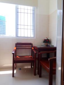 une chambre avec deux tables, une chaise et une fenêtre dans l'établissement DUY HUY hotel & apartment, à Nha Trang