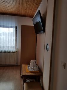 a room with a table and a television on the wall at House Anamarija in Seliste Dreznicko