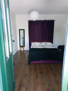 a bedroom with a bed with a purple curtain at Apartments Lozina in Živogošće