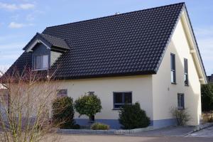ein weißes Haus mit schwarzem Dach in der Unterkunft Rieslingstube bei Britta & Joachim in Undenheim