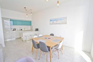 a kitchen and dining room with a wooden table and chairs at PROMENADE HOLIDAY - AZUR PROMENADE in Nice