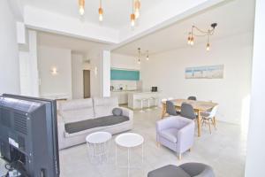 a living room with a couch and a tv and a table at PROMENADE HOLIDAY - AZUR PROMENADE in Nice