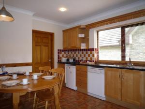 a kitchen with a wooden table and a table and chairs at Galway Bay Lodge in Oranmore