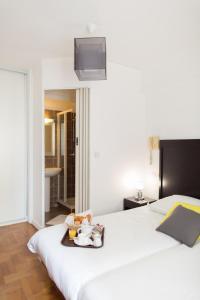 - une chambre d'hôtel avec un lit et un plateau de nourriture dans l'établissement Esperanto, à Cannes