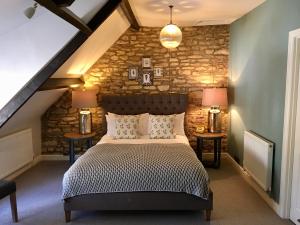 una camera con un letto e due tavoli con lampade di The Sheep on Sheep Street Hotel a Stow on the Wold