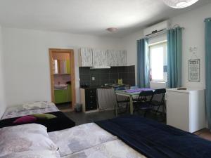 a bedroom with a bed and a kitchen with a table at Apartments Lozina in Živogošće