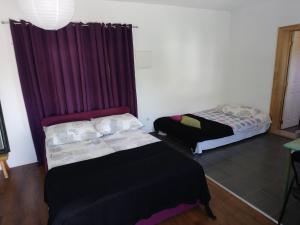 a room with two beds and a purple curtain at Apartments Lozina in Živogošće