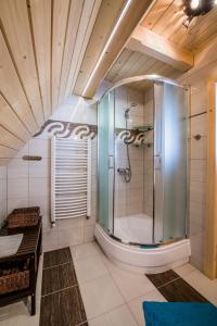 a bathroom with a shower with a bench and a table at Domek Góralski in Poronin +14 photos