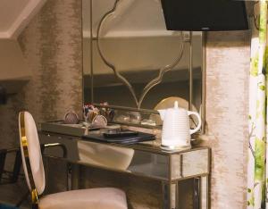 a room with a desk with a vase and a mirror at Leighinmohr House Hotel in Ballymena