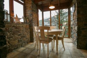 a dining room with a table and chairs and windows at B&B La Lluna in La Massana