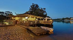 a restaurant on a dock with a boat on the water at THE LAKERS Boutique Apartment in Quinta do Lago