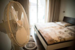 a bedroom with a bed with a fan at Kronlachner's Apartment in Wolfsegg am Hausruck