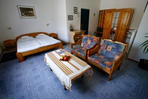 1 dormitorio con 2 camas, mesa y sillas en Keszi Panzió, en Budakeszi
