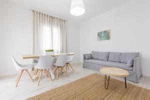 a living room with a couch and a table and chairs at Apartamentos Baltum in Albufeira