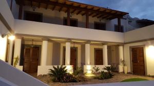 a large white house with columns and lights at Le 7 sorelle in Lipari
