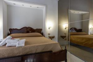 ナポリにあるEdoardo al Plebiscitoのベッドルーム1室(ベッド2台、鏡付)