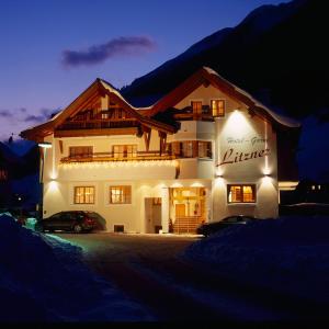 a lit up building in the snow at night at Hotel Garni Litzner in Ischgl
