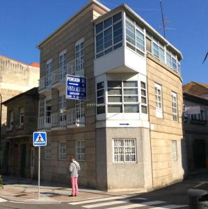 a woman standing in front of a building at Pensión Vista Alegre in Vigo