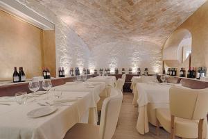 una sala da pranzo con tavoli bianchi e bottiglie di vino di LUX Suites in Roma a Roma