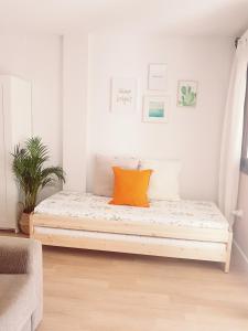 1 cama con almohada naranja en una habitación en Estudio Pueblo Evita 133, en Benalmádena