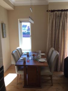 a dining room table with chairs and a table and a window at Beautiful Killarney Apartment in Killarney +15 photos