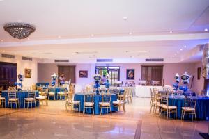 a banquet hall with blue tables and chairs at Hotel Galeria in Santiago