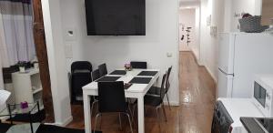 a dining room with a white table and black chairs at M&F Apartments Sol in Madrid