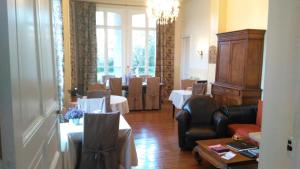 a room with a dining room with tables and chairs at Manoir de la Marjolaine in Cabourg