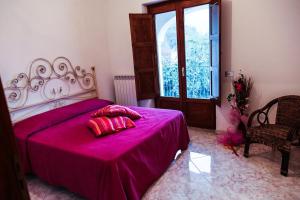 una camera da letto con un letto con lenzuola rosa e una finestra di Il Vigneto a Tramonti