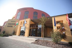 a building with flags in front of it at Colosseum Hotel in Mórahalom