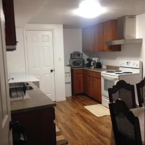 cocina con suelo de madera y estufa blanca en Wright's Creek Apartment, en Charlottetown