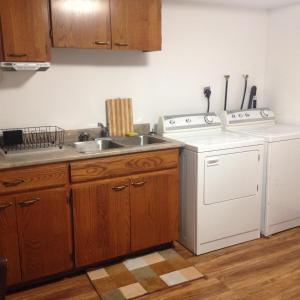 a kitchen with a sink and a washing machine at Wright's Creek Apartment in Charlottetown