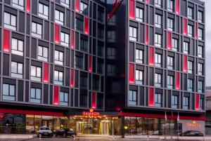 イスタンブールにあるRamada by Wyndham Istanbul Alibeykoyの赤いドアと窓のある高い黒い建物