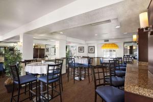 a restaurant with tables and chairs and a bar at Ramada by Wyndham Costa Mesa/Newport Beach in Costa Mesa