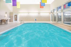 ein großer Pool mit blauem Wasser in einem Gebäude in der Unterkunft Ramada by Wyndham Springfield North in Springfield
