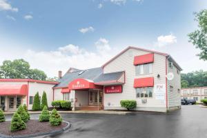 グロトンにあるRamada by Wyndham Groton Mysticの駐車場の赤い日よけ付きのmcdonaldsレストラン
