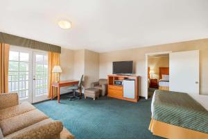 フラッグスタッフにあるRamada by Wyndham Flagstaff Eastのベッドとデスクが備わるホテルルームです。