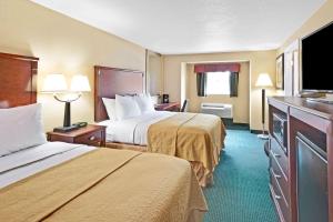 a hotel room with two beds and a flat screen tv at Ramada by Wyndham Kittery in Kittery